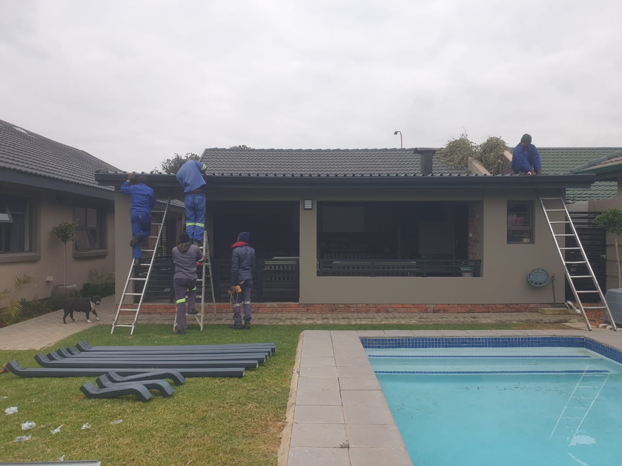 Get Guttered team installing gutters along a residential roofline
